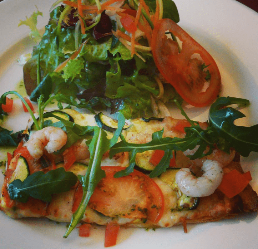 Pizzeta de carbassó, gambes, mozzarela i fines herbes, mesclum d'enciam